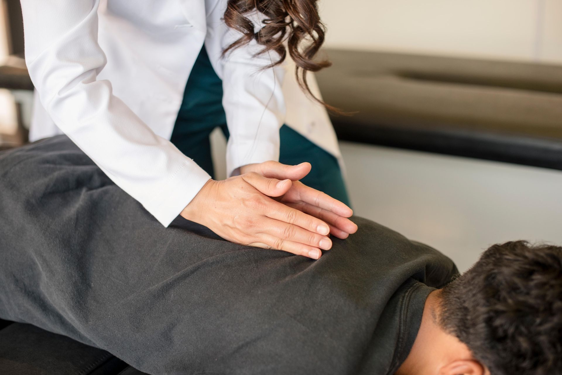 Physical therapist stretching a patient’s leg on a treatment table in a bright clinic room