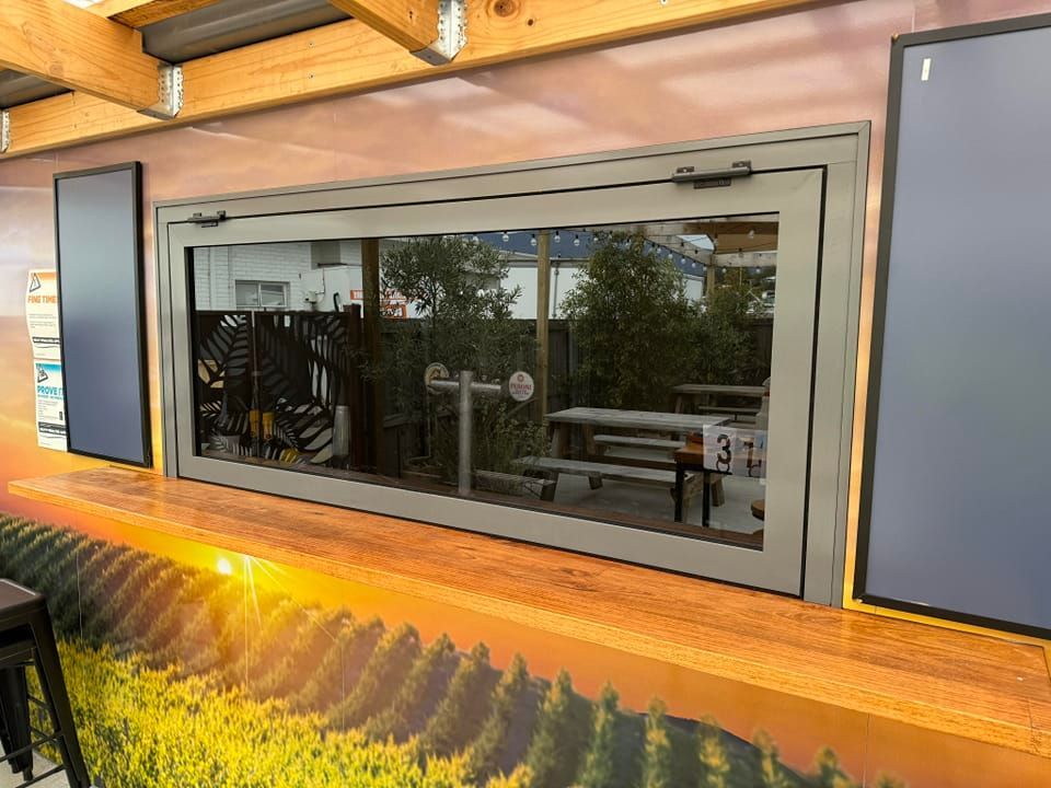 A Serving Window With a Wooden Counter and a Mural of a Vineyard — Channel Glazing In Electrona, TAS
