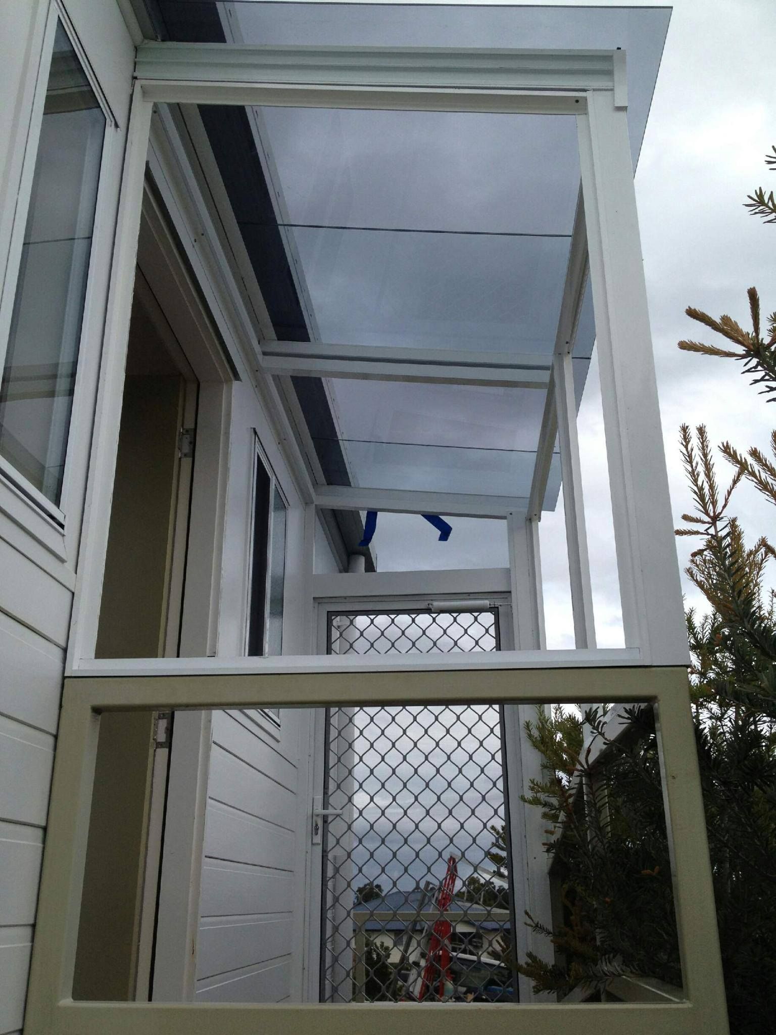 A White, Metal-framed Porch Covering Attached to a House Exterior — Channel Glazing In Electrona, TAS