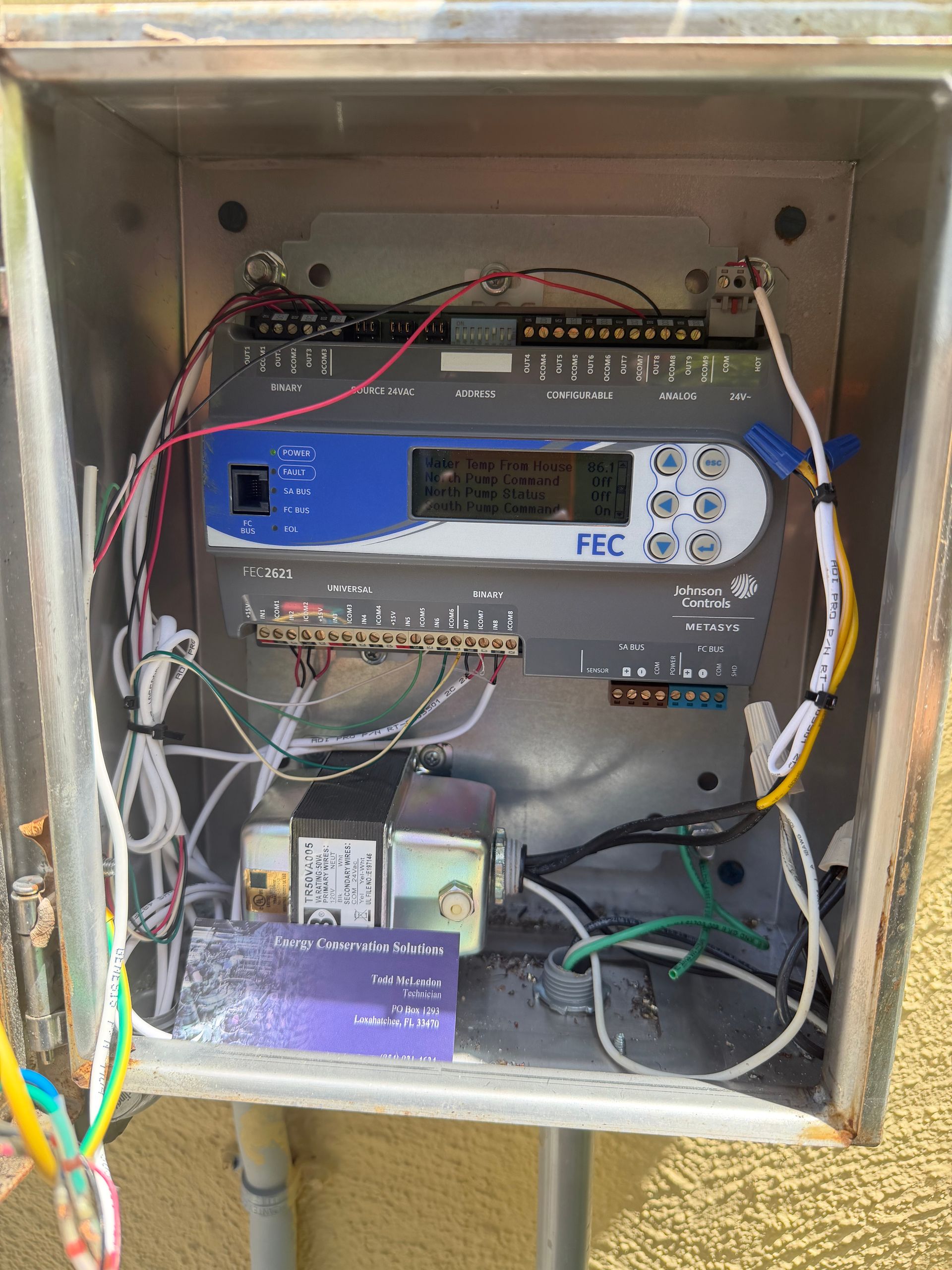 Open electrical control panel with wiring, breakers, and relays inside a metal box