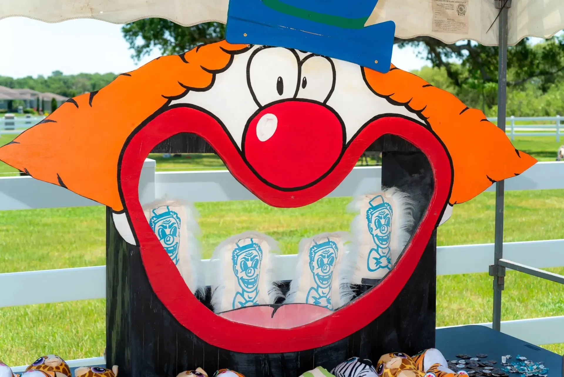 A clown face with a blue hat and red nose