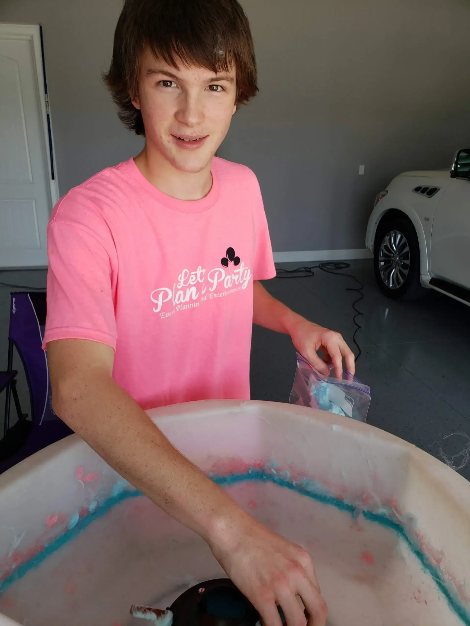 a boy making cotton candy in a machine
