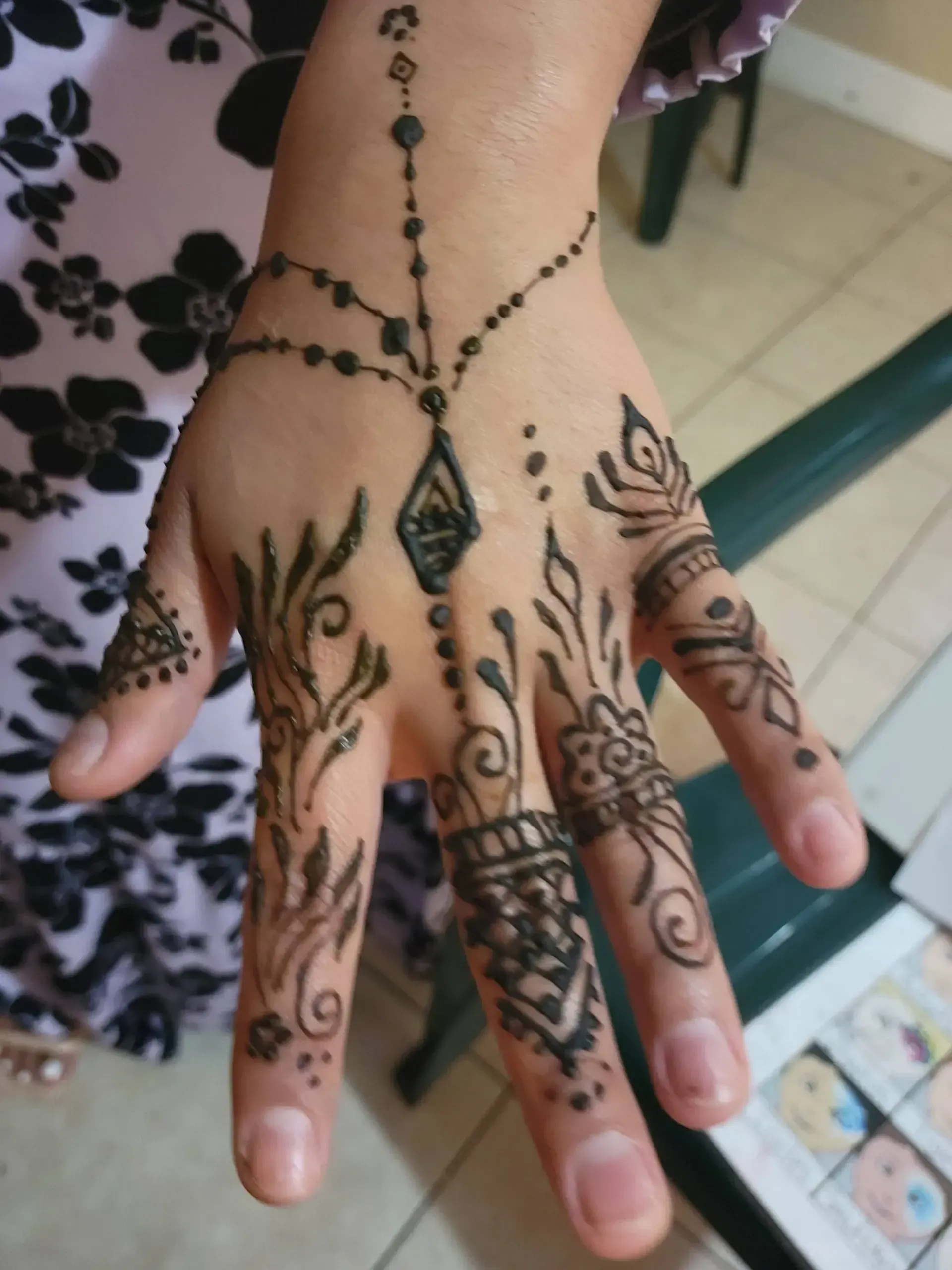 A close up of a woman 's hand with henna on it