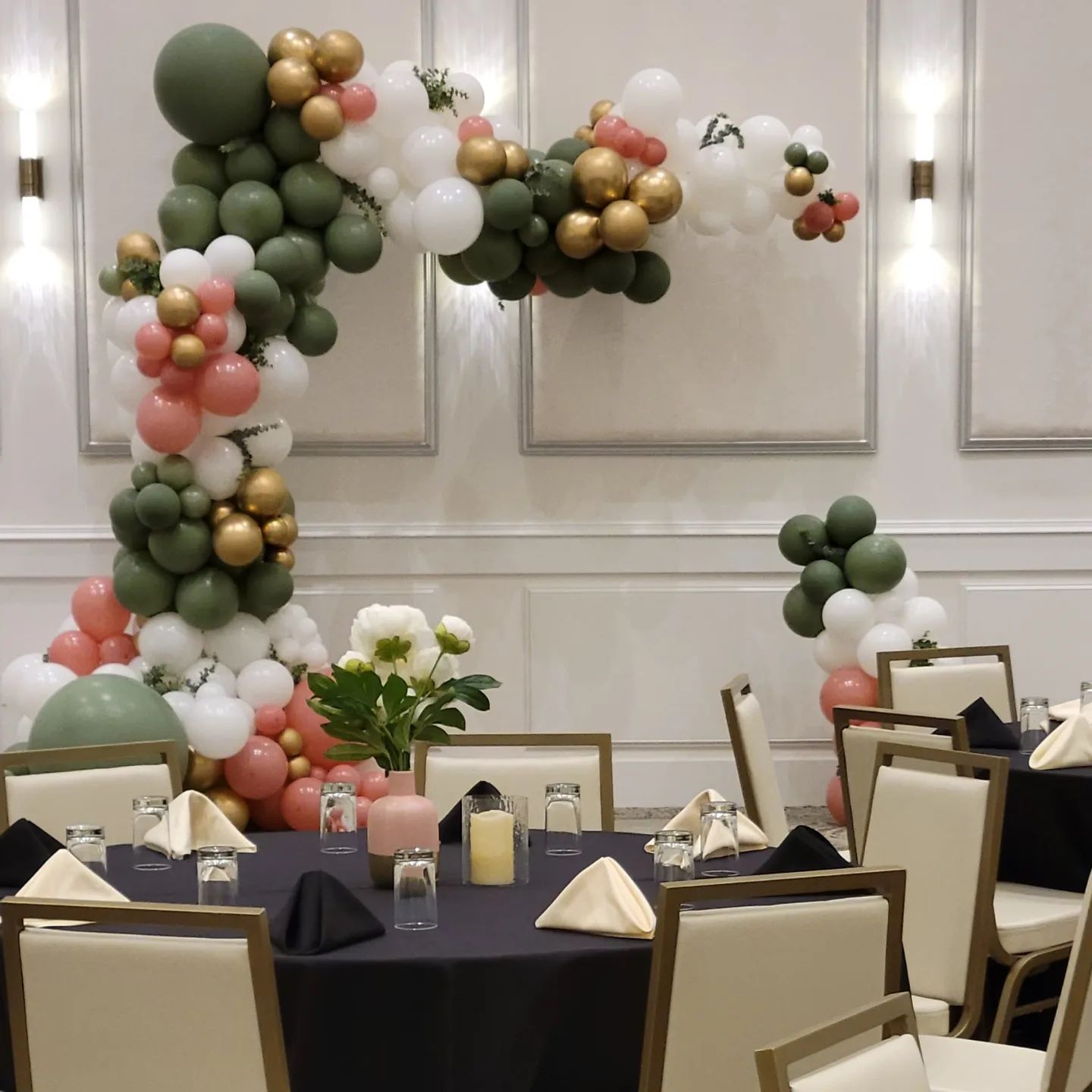 A room with tables and chairs decorated with balloons and flowers