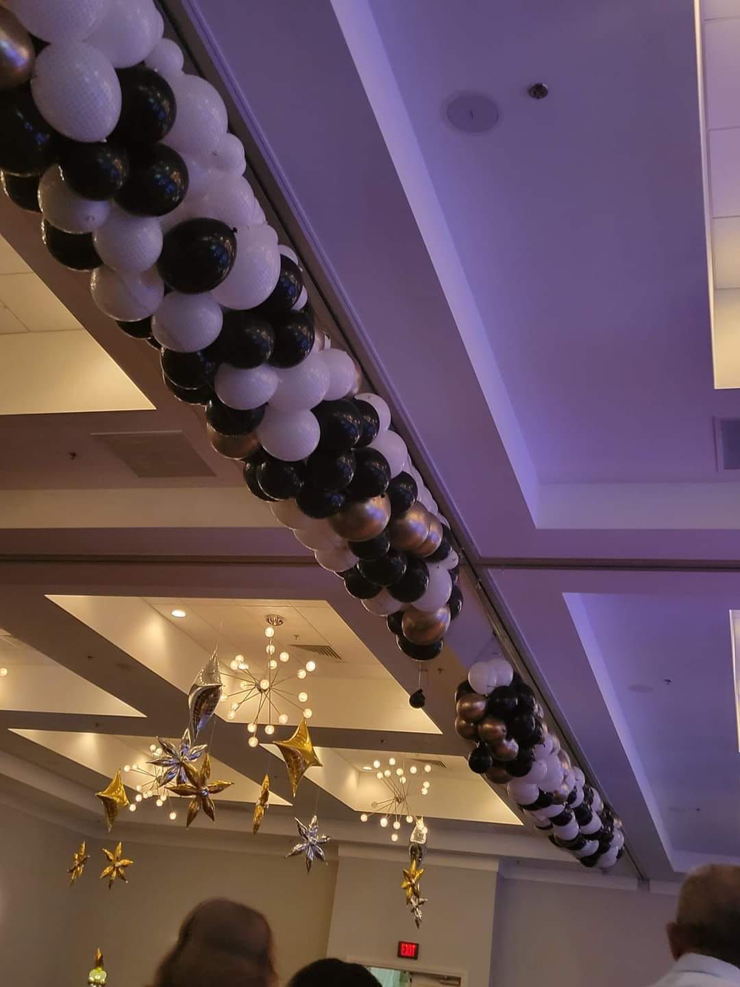 A bunch of balloons are hanging from the ceiling