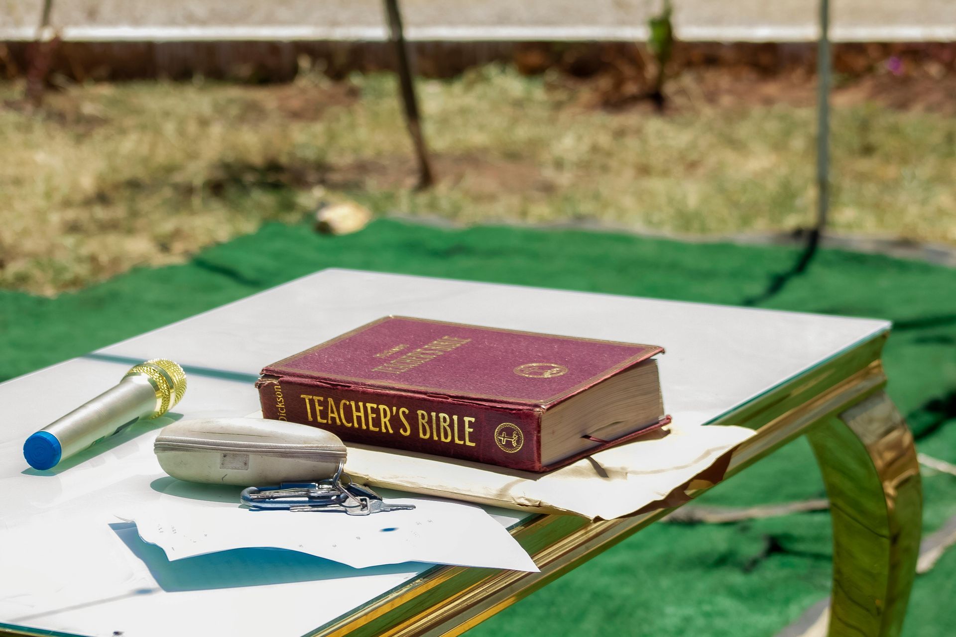 A purple bible is sitting on a table outside