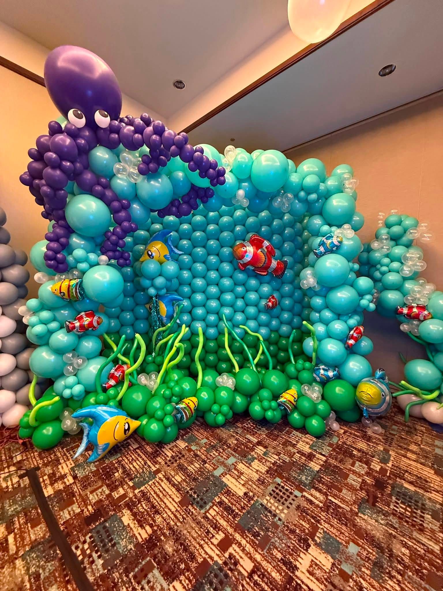 Colorful balloon coral reef scene with fish and seaweed decorations in a conference room