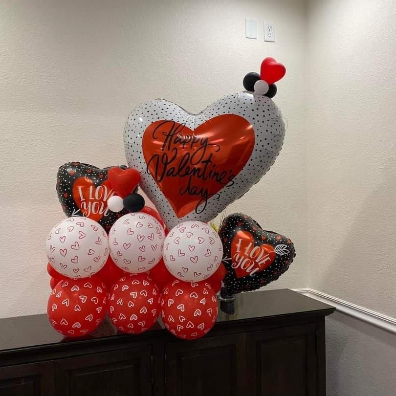 A bunch of valentine 's day balloons on a table