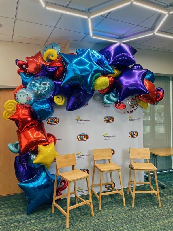 A room with chairs and balloons on the wall