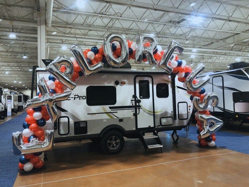A rv is decorated with balloons and says explorer
