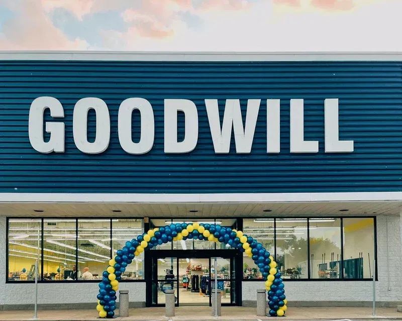 The front of a goodwill store with balloons in front of it.