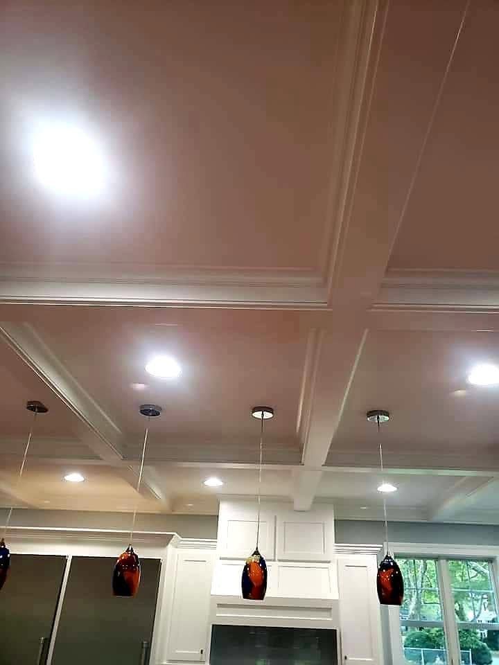 Ceiling with recessed lights and hanging red-and-black punching bags in a gym interior