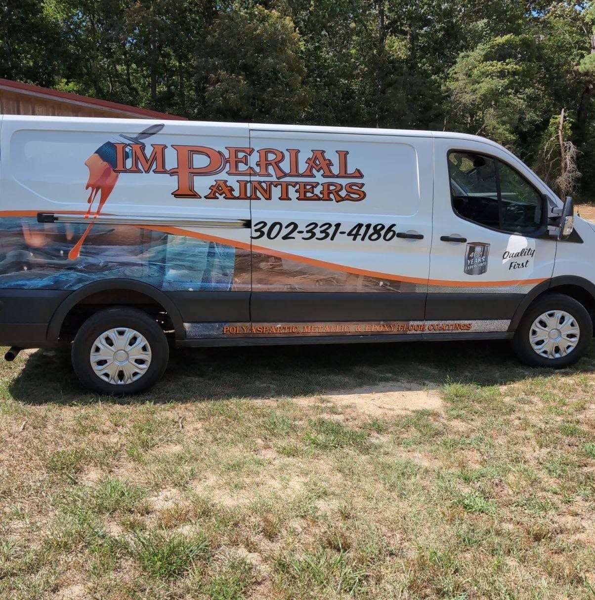 White Imperial Interiors van with ocean mural parked on grass, displaying phone number 302-337-4186.