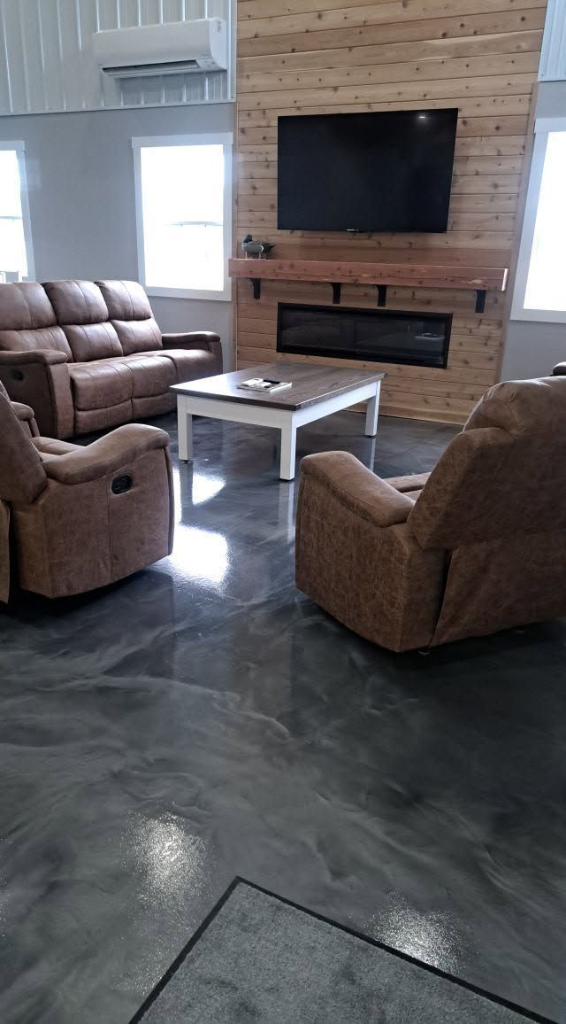 Cozy living room with two recliners, a coffee table, wall-mounted TV, and fireplace on a brick accent wall.