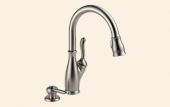 A stainless steel kitchen sink faucet with a soap dispenser attached to it.