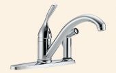 A close up of a chrome kitchen sink faucet on a beige background.