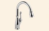 A close up of a kitchen faucet on a white background.