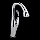A close up of a kitchen faucet on a black background.