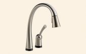 A stainless steel kitchen faucet with a black handle on a white background.