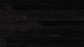 A close up of a black wood grain texture.