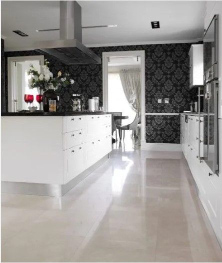 A kitchen with white cabinets and black wallpaper