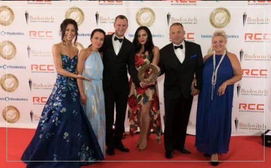 A group of people are posing for a picture on a red carpet.