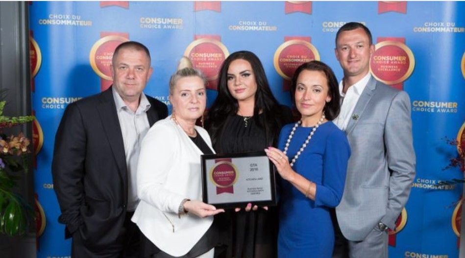 A group of people standing next to each other holding a framed award.