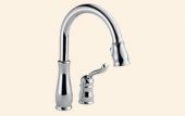 A close up of a chrome kitchen faucet on a white background.