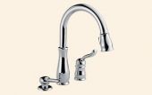 A chrome kitchen faucet with a pull out sprayer on a white background.