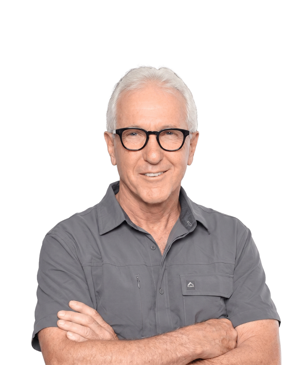 Smiling man with white hair and glasses, arms crossed, wearing a gray shirt on a white background