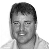 Smiling man with short dark hair, wearing a light-colored polo shirt.