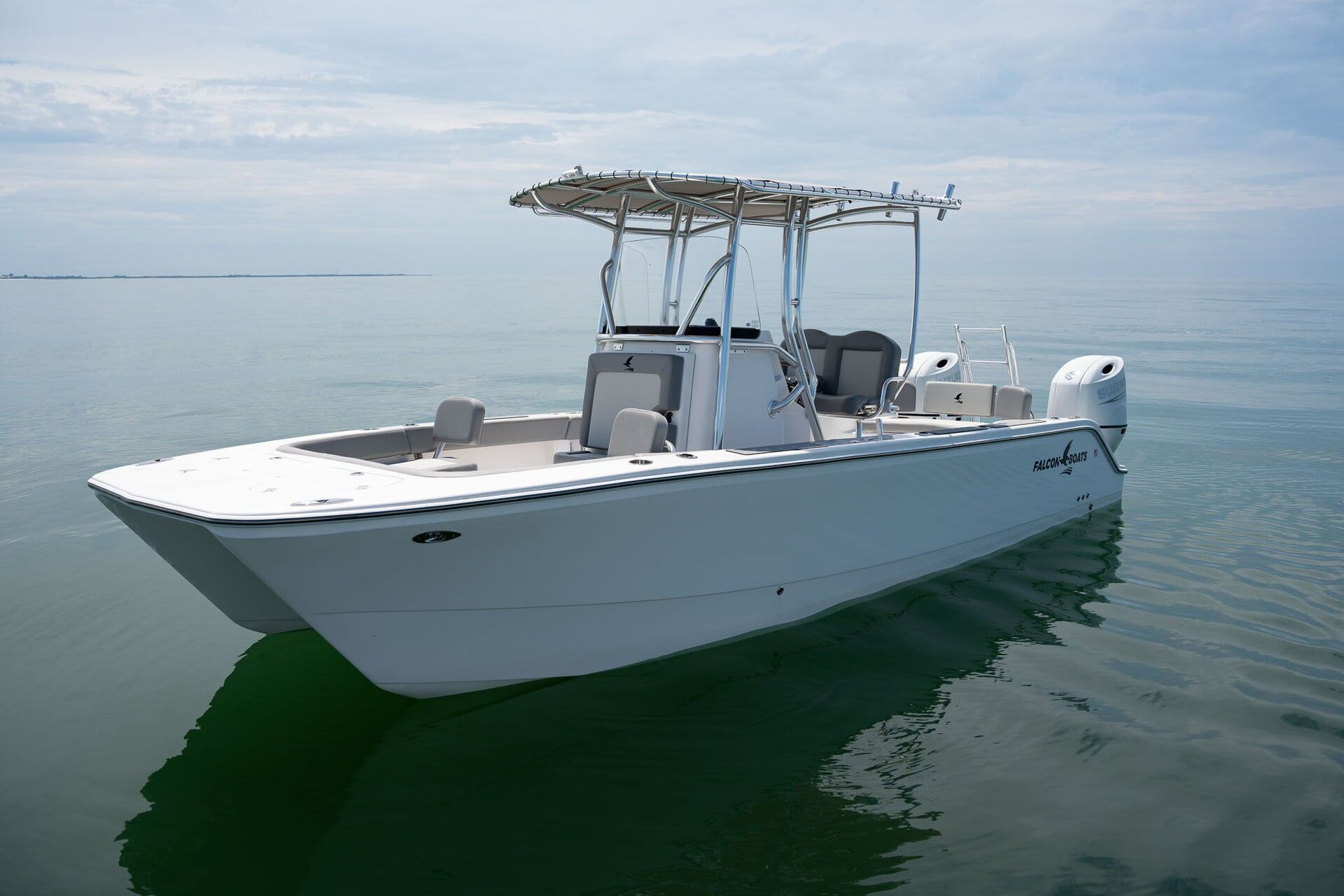 A boat on a trailer inside a building, featuring a blue and black graphic design on its side and a large white motor.