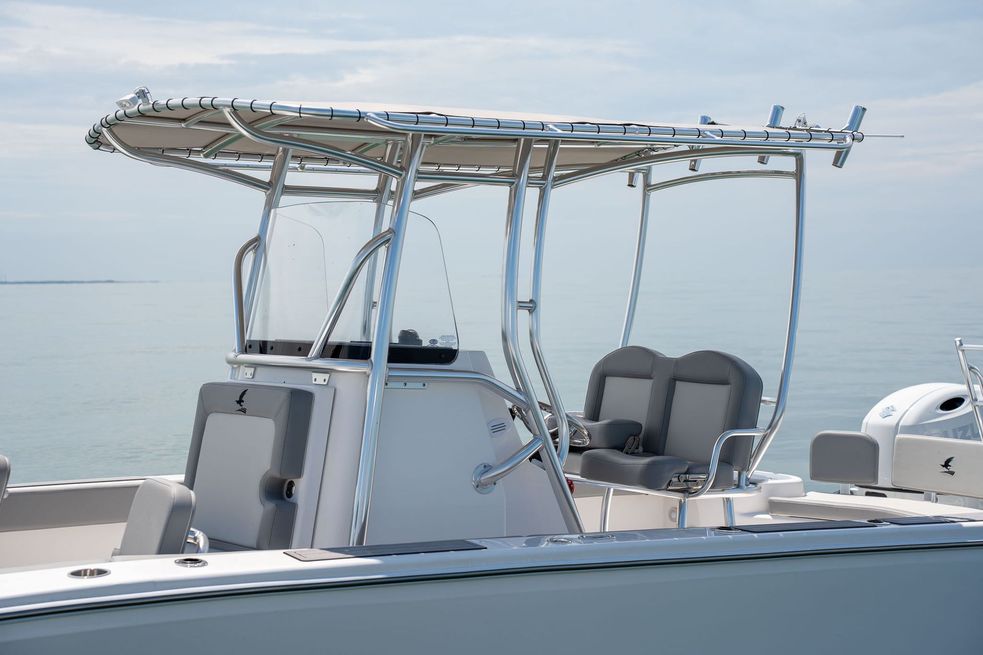 Boat on a trailer inside a building, with a gray and turquoise patterned wrap, and a silver aluminum tower.