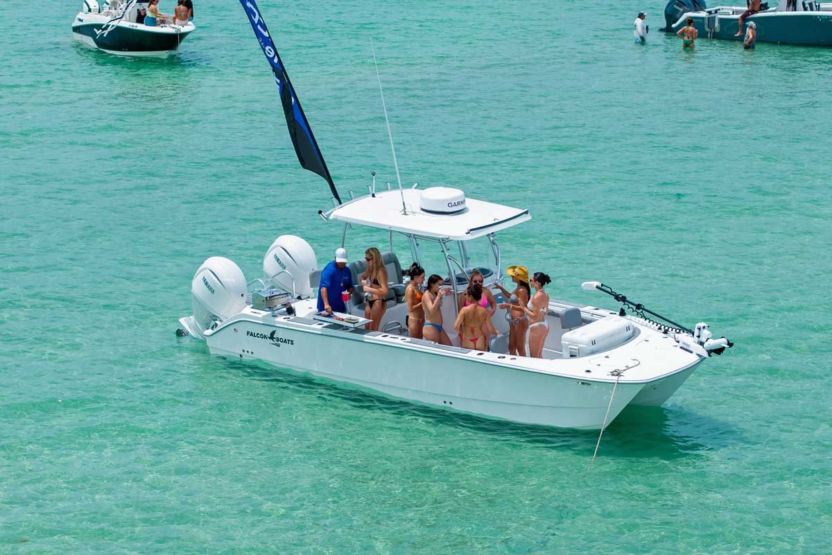 People on a white Falcon catamaran in turquoise water near other boats