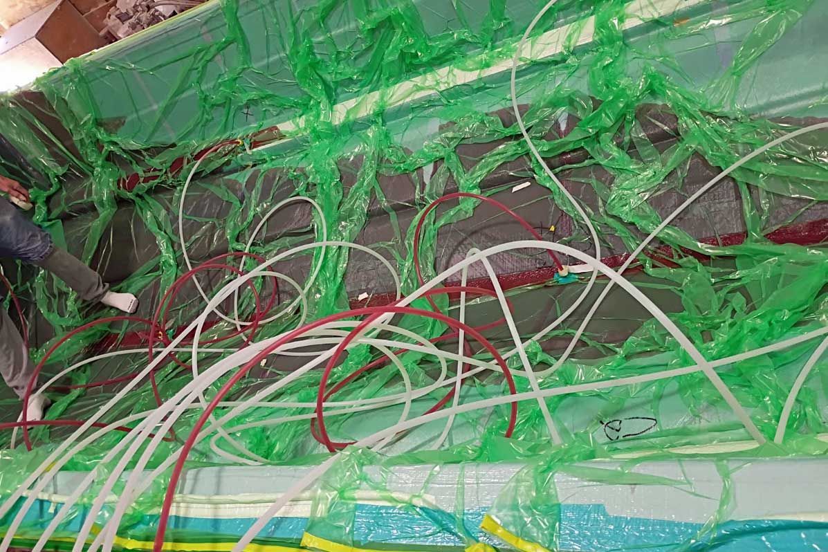 A tangle of green, red, and white wires used in vacuum infused hulls