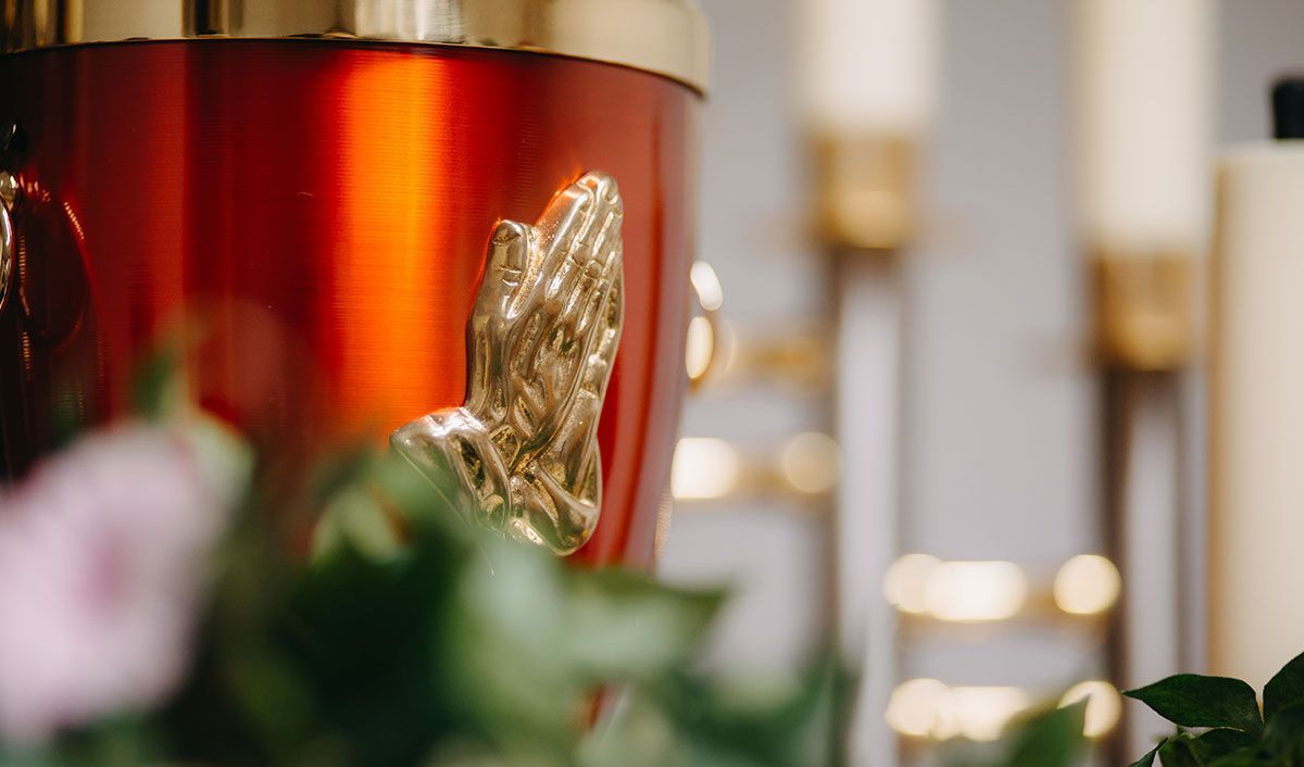 Beautiful cremation urn with prayer hands decoration