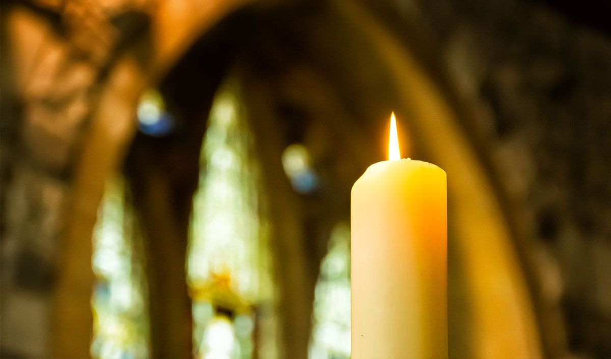 Memorial candle burning in a Catholic church lit in prayer for a loved one