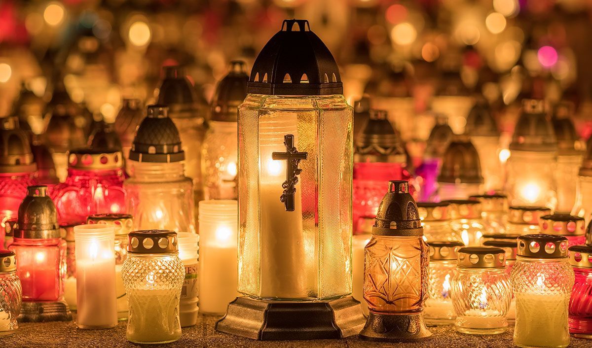 Group of lit ceremony candles on grave