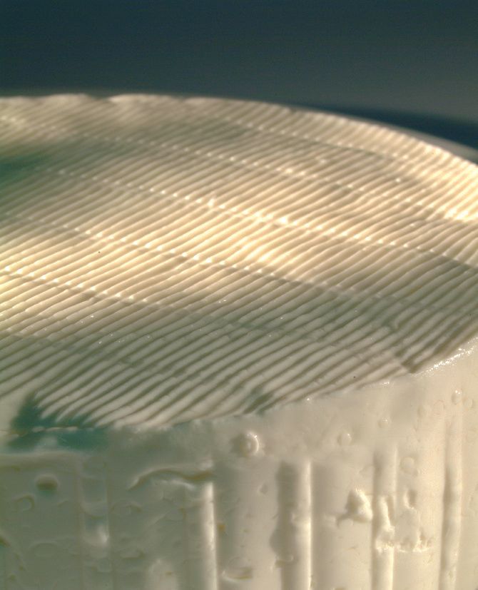 Primo piano di una torta glassata a strisce verdi e bianche con lati lisci.