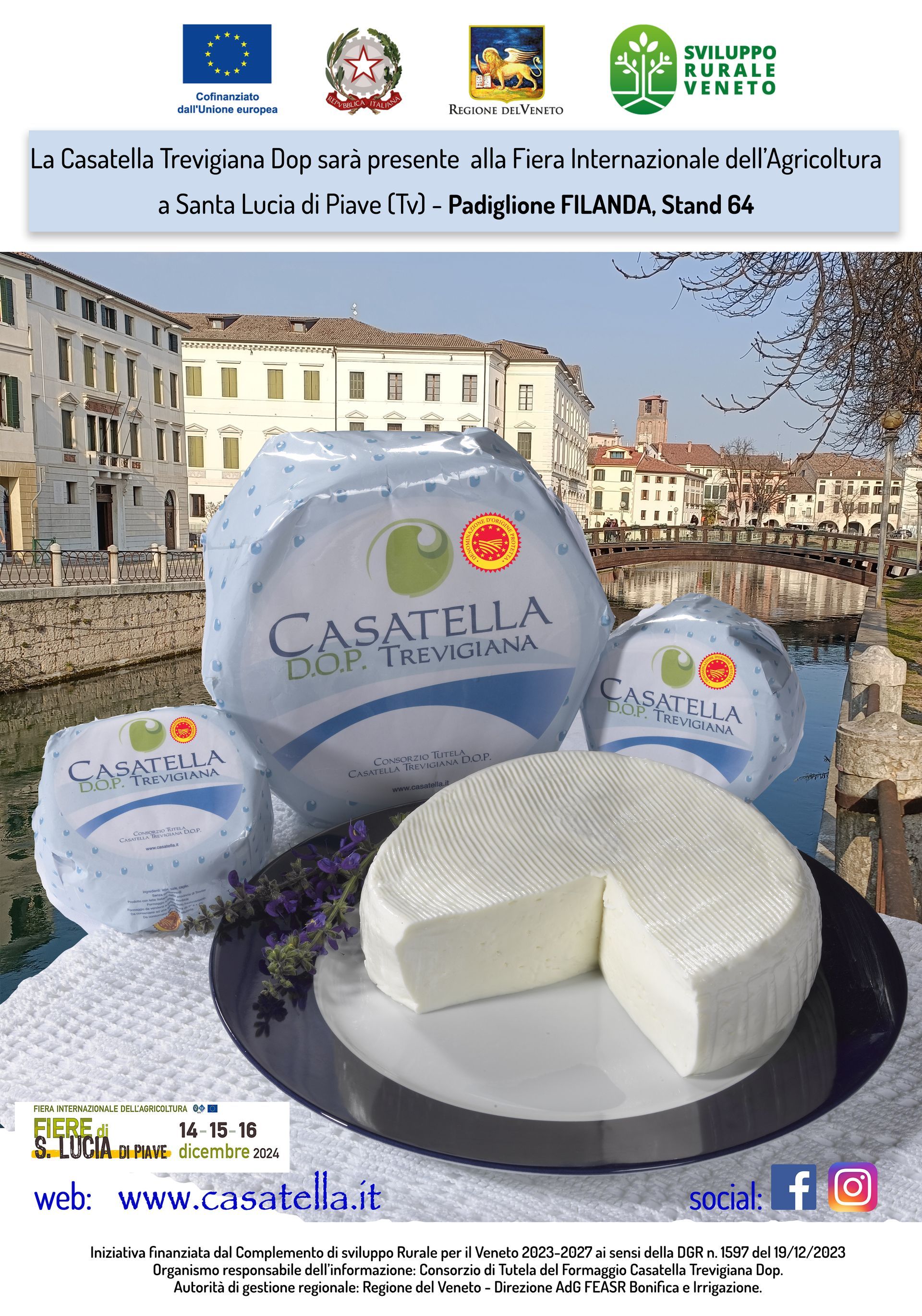 Forme di formaggio, una delle quali tagliata a metà su un piatto, di fronte a una piazza cittadina e striscioni promozionali.