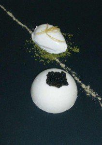 Due caramelle bianche su una superficie scura, una ricoperta di sciroppo bianco e l'altra con guarnizione nera.