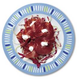 Piatto con bordo blu, affettato con salumi e scaglie di formaggio bianco.