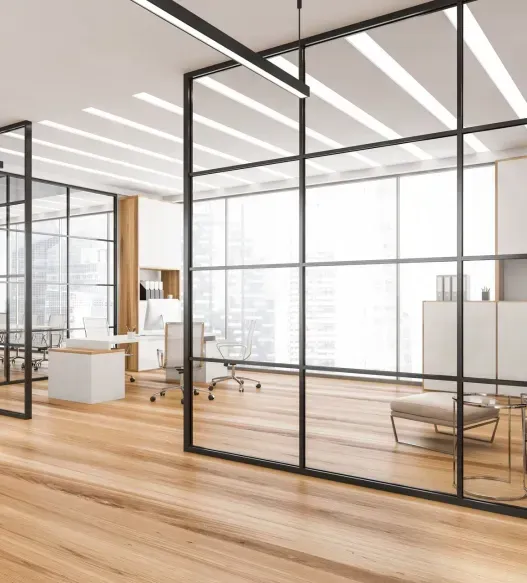 A modern office with a lot of windows and wooden floors.