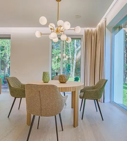 A dining room with a table and chairs and a chandelier hanging from the ceiling.