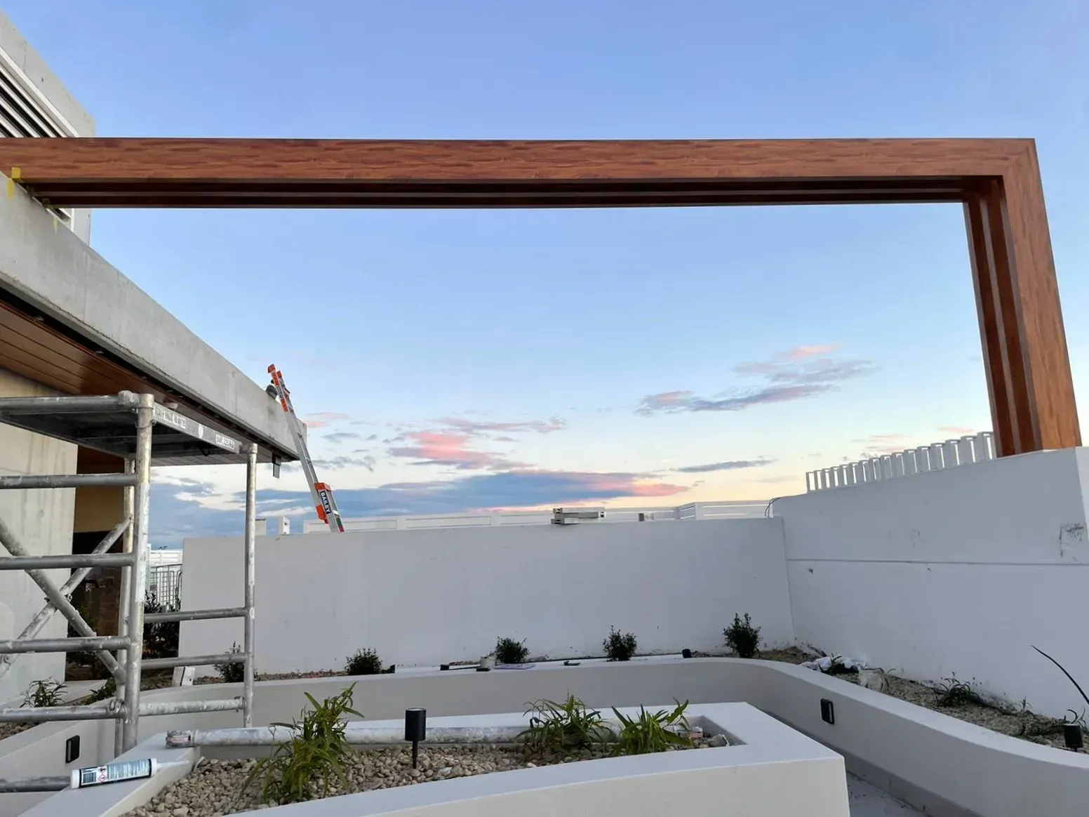 A wooden pergola is being built on the roof of a building.
