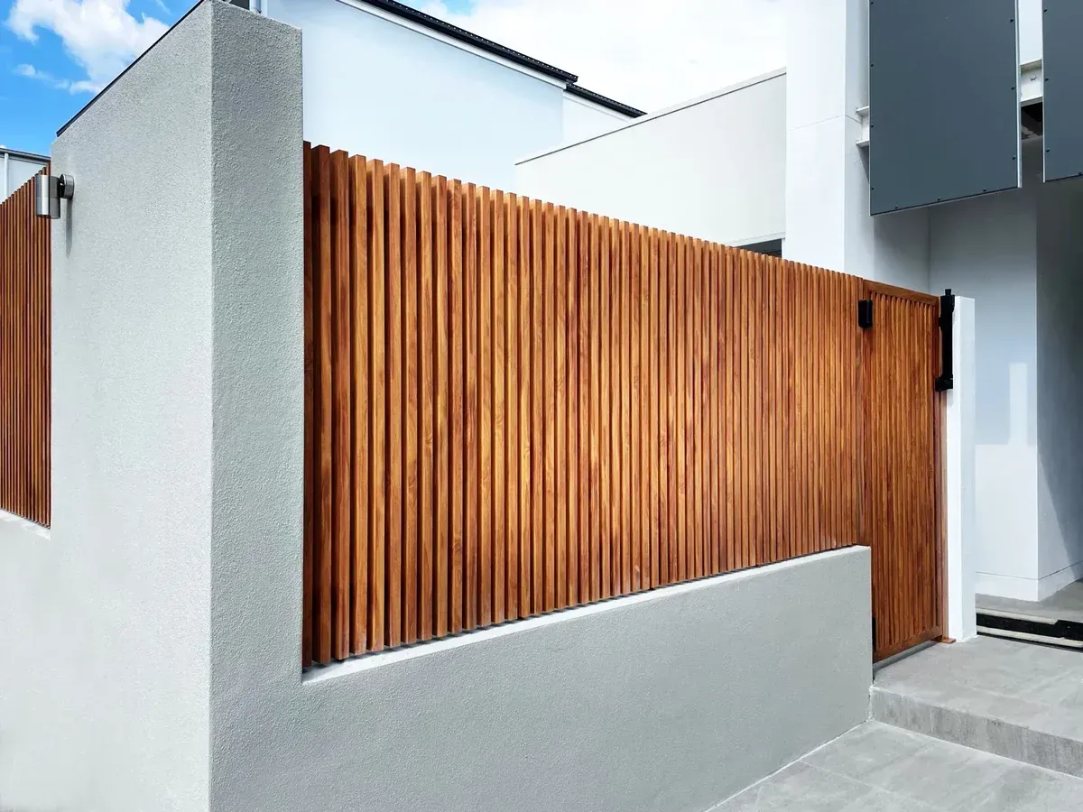 A white building with a wooden fence and a gate