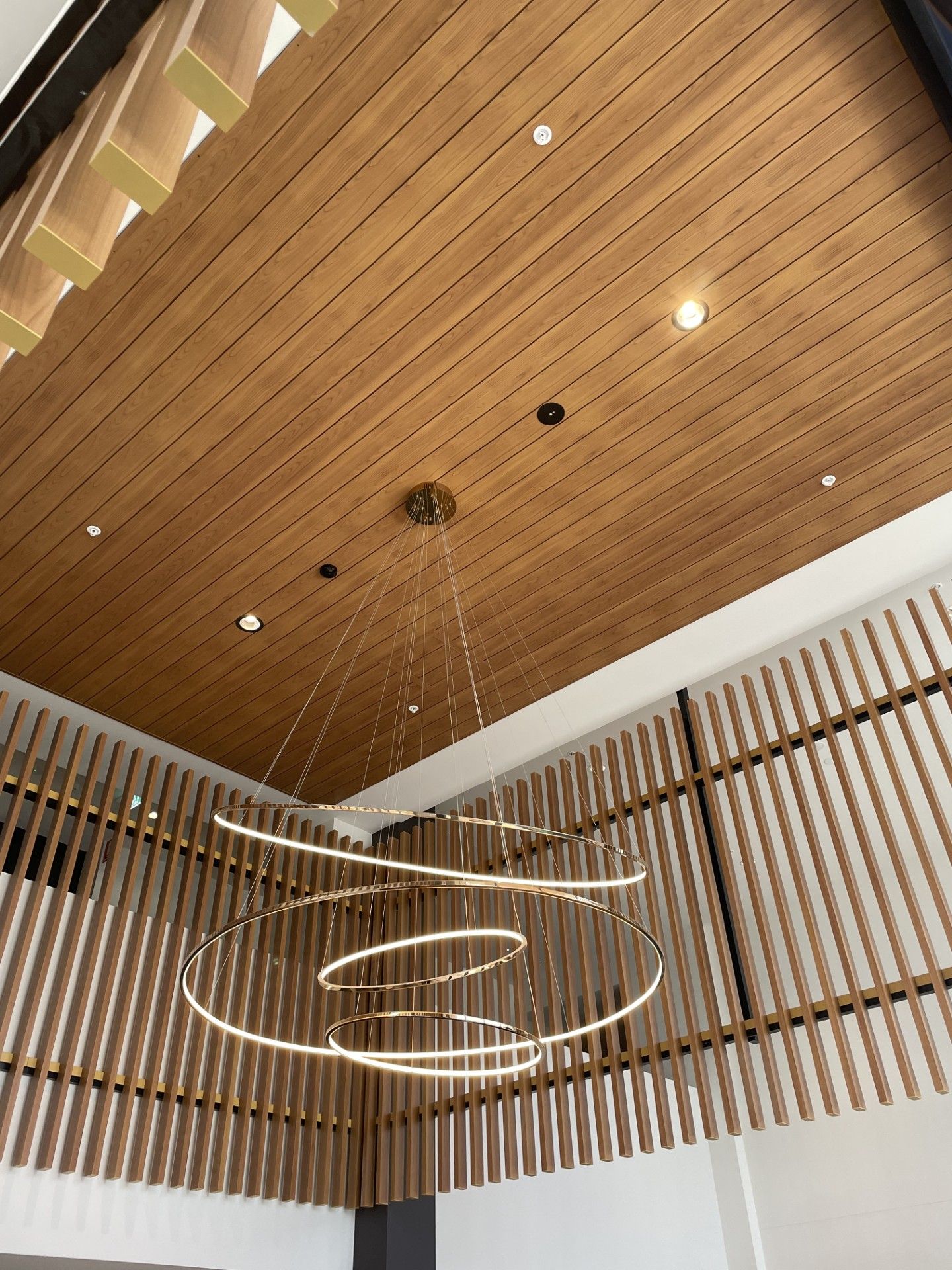 A wooden ceiling with a chandelier hanging from it.