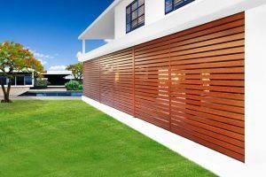 A large white house with wooden blinds on the side of it.