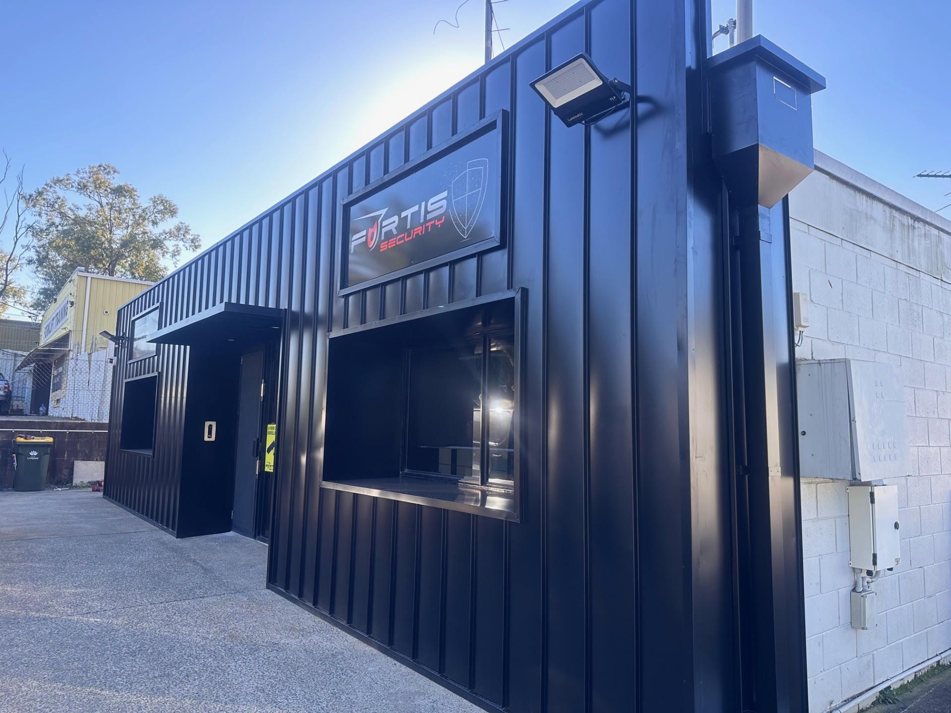 A black building with a sign on the side of it.