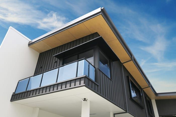 A large house with a balcony and a blue sky in the background.